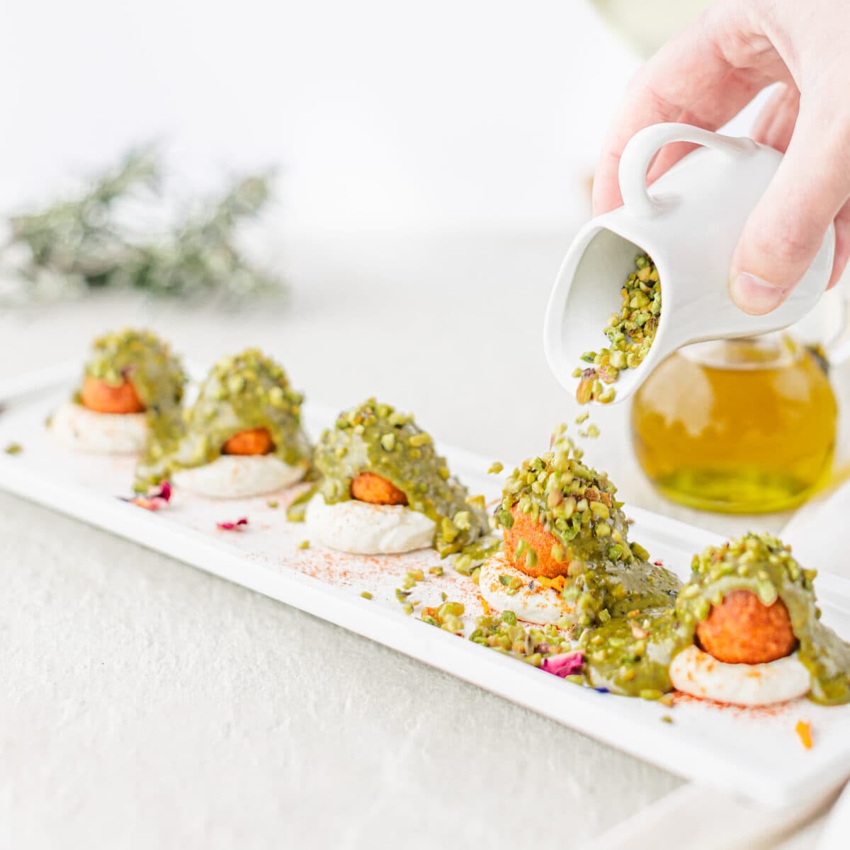 Polpette di Astice panate alla nduja con cuore fondente di Caciocavallo Silano DOP e Gambero rosa su Crema di ricotta al Lime e Paprika dolce. Glassate al Pistacchio e ricoperte di granella.